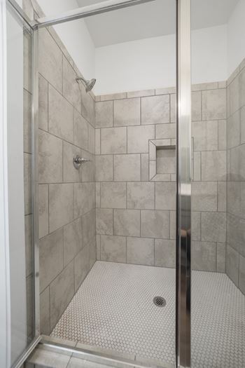 A shower with a glass door and tiled walls at Turnberry Park Luxury Rental Homes in Gardendale, AL